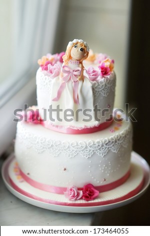 Beautiful pink birthday cake with little doll figurine on top