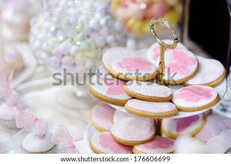 Wedding cookies decorated with pink flowers and butterflies