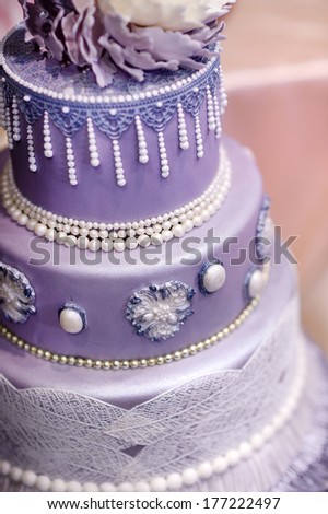 Purple wedding cake decorated with flowers and pearls