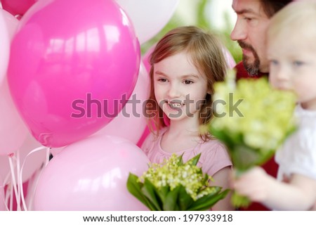 Little birthday girl with pink balloons and flowers