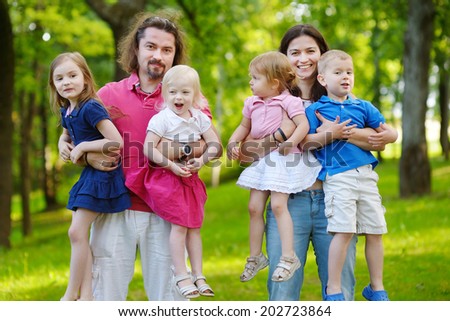 Happy big family of six having fun at summer park on beautiful sunny day