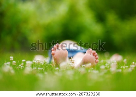 Childrens feet on grass outdoors in summer park
