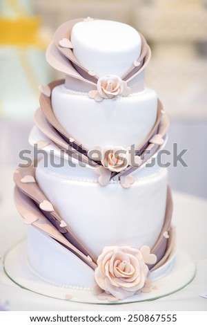 White wedding cake decorated with beige sugar flowers