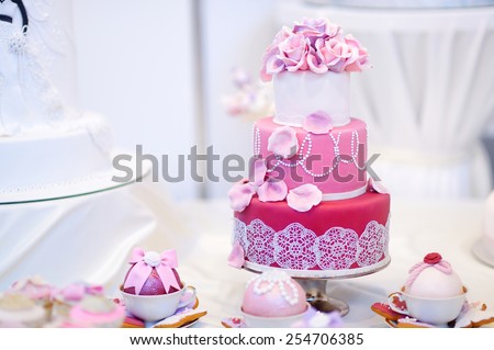 White wedding cake decorated with pink sugar flowers