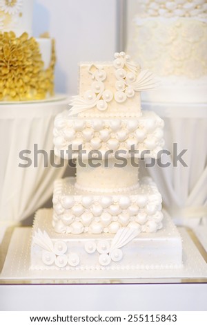 Fancy delicious white wedding cake decorated with flowers and butterflies
