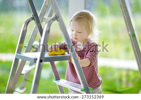 Little toddler girl helping her mom to clean up on spring day