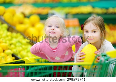 Cute little sisters shopping in a food store or a supermarket