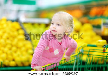 Cute little toddler girl shopping in a food store or a supermarket