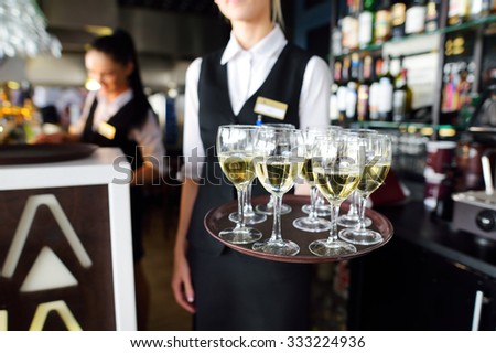 Waitress holding a dish of champagne and wine glasses at some festive event, party or wedding reception