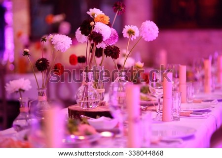 Table set for an event party or wedding reception in purple light