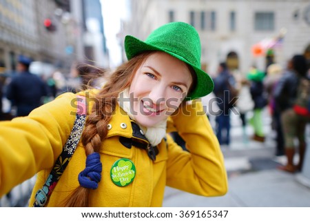 Young tourist taking a selfie with her smartphone during the annual St. Patrick\'s Day Parade on 5th Avenue in New York City
