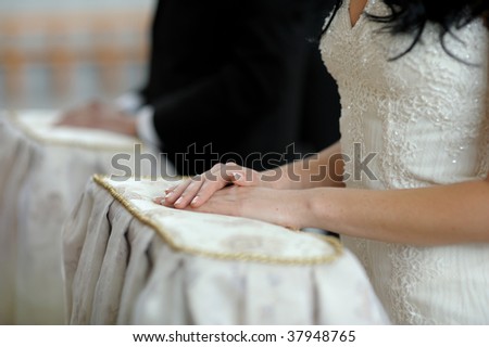 Bride\'s hands on the pillow during wedding church ceremony