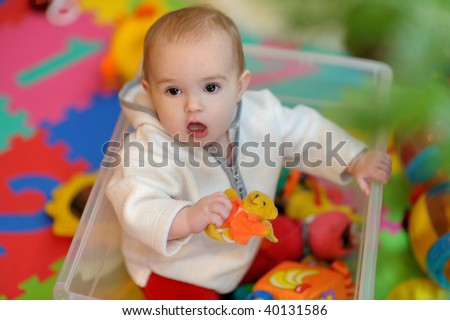 Pretty little girl sitting in a toy box
