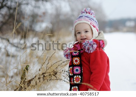 Little winter baby girl in red coat