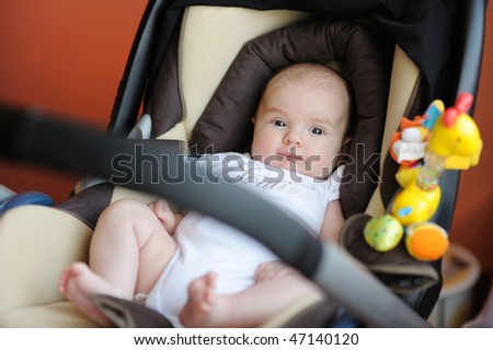 Little two month baby playing in a car seat