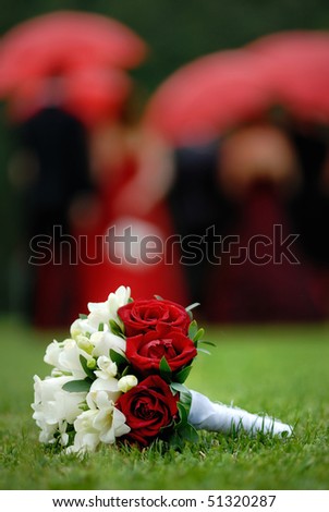 stock photo Wedding flowers on the grass and people with umbrellas in 