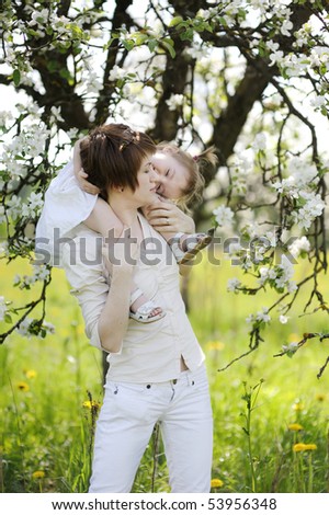 Young mother and her daughter in blossoming trees