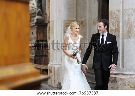Bride and groom smiling at the church after a wedding ceremony