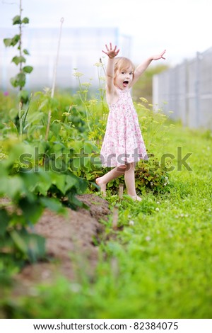 Little girl fooling around in a garden