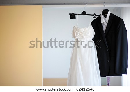 stock photo Wedding dress and a tuxedo hanging on a shoulders