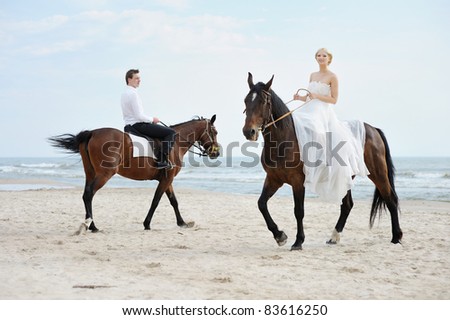 stock photo Beach wedding bride and groom on a horses by the sea