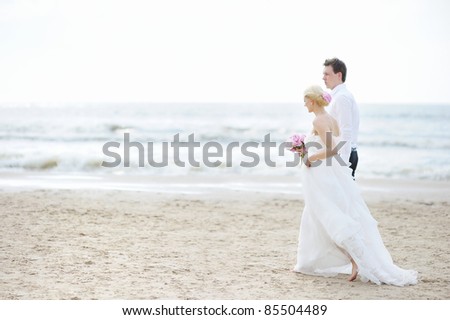 stock photo Beach wedding bride and groom by the sea