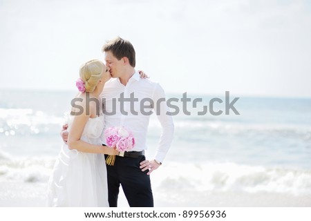 stock photo Beach wedding bride and groom by the sea