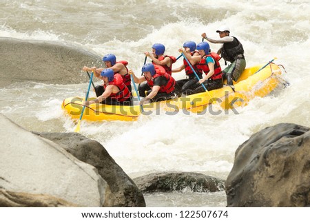 A GROUP OF MEN AND WOMEN, WITH A GUIDE, WHITEWATER RAFTING ON THE PATATE RIVER, ECUADOR