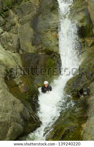 Canyoning guide trying out a new route in Chama waterfall, Banos De Agua Santa, Ecuador