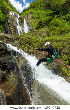 Canyoning guide trying out a new route in Chama waterfall, Banos De Agua Santa, Ecuador