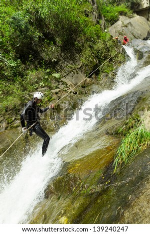 CANYONING GUIDE TRYING OUT A NEW ROUTE IN CHAMA WATERFALL, BANOS DE AGUA SANTA, ECUADOR