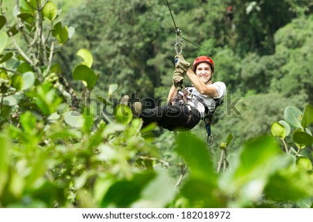 Adult man on zip line, Andes rain forest in Ecuador
