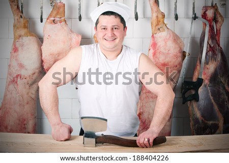 muscular butcher portrait at his workplace with a large ax