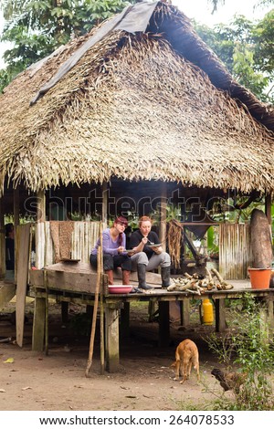 TOURIST HAVING LUNCH ON INDIGENOUS HOUSE PORCH