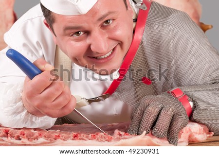 butcher at his workplace presenting his way of chopping pork meat