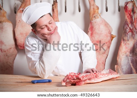 candid portrait of a butcher with a piece of meat on his table