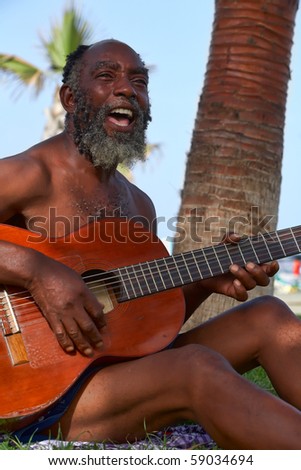 Old black men playing guitar on a tropical island