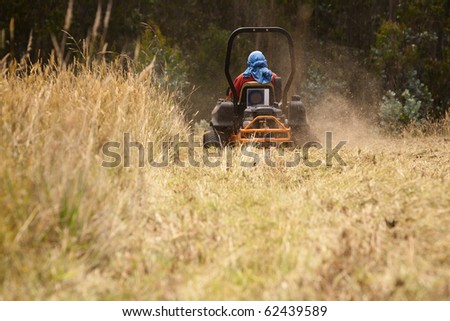 Riding lawn mower blowing grass