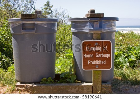 Public trash cans with sign.