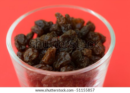 Selective focus image of raisins in a glass which are often in cereal products like muesli.