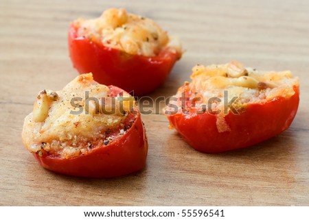 Tomatoes grilled with parmesan cheese and pignolias, served as starter.
