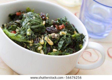 Indian cooked spinach with raisins, pine nuts and red pepper.