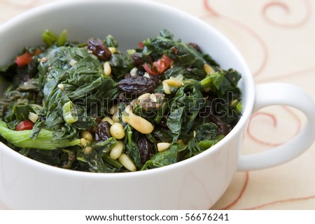Indian cooked spinach with raisins, pine nuts and red pepper.