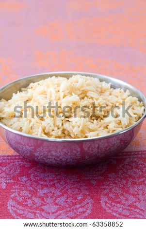 Bowl with rice which is cooked in Indian style.
