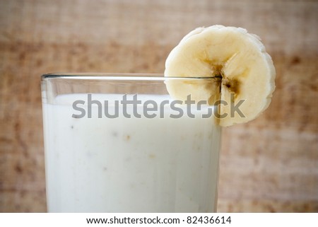 Glass with banana milk and banana slices.