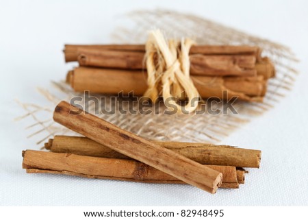 Close up image of cinnamon sticks on a white cover.