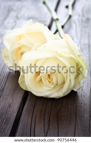 Close up image of yellow roses on a wooden background with copy space.