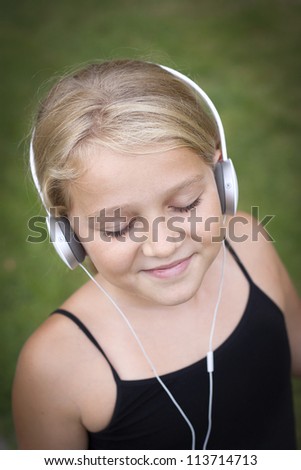 smiling child with headset listening to music