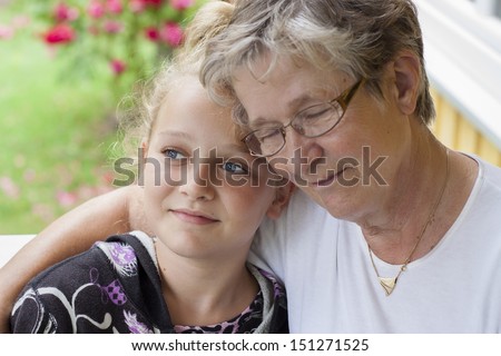 a grandmother and grandchild looking at camera, candid photo, real people