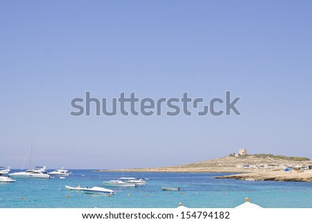 Coastline in Malta with blue sea, blue sky and power boats. Space for text